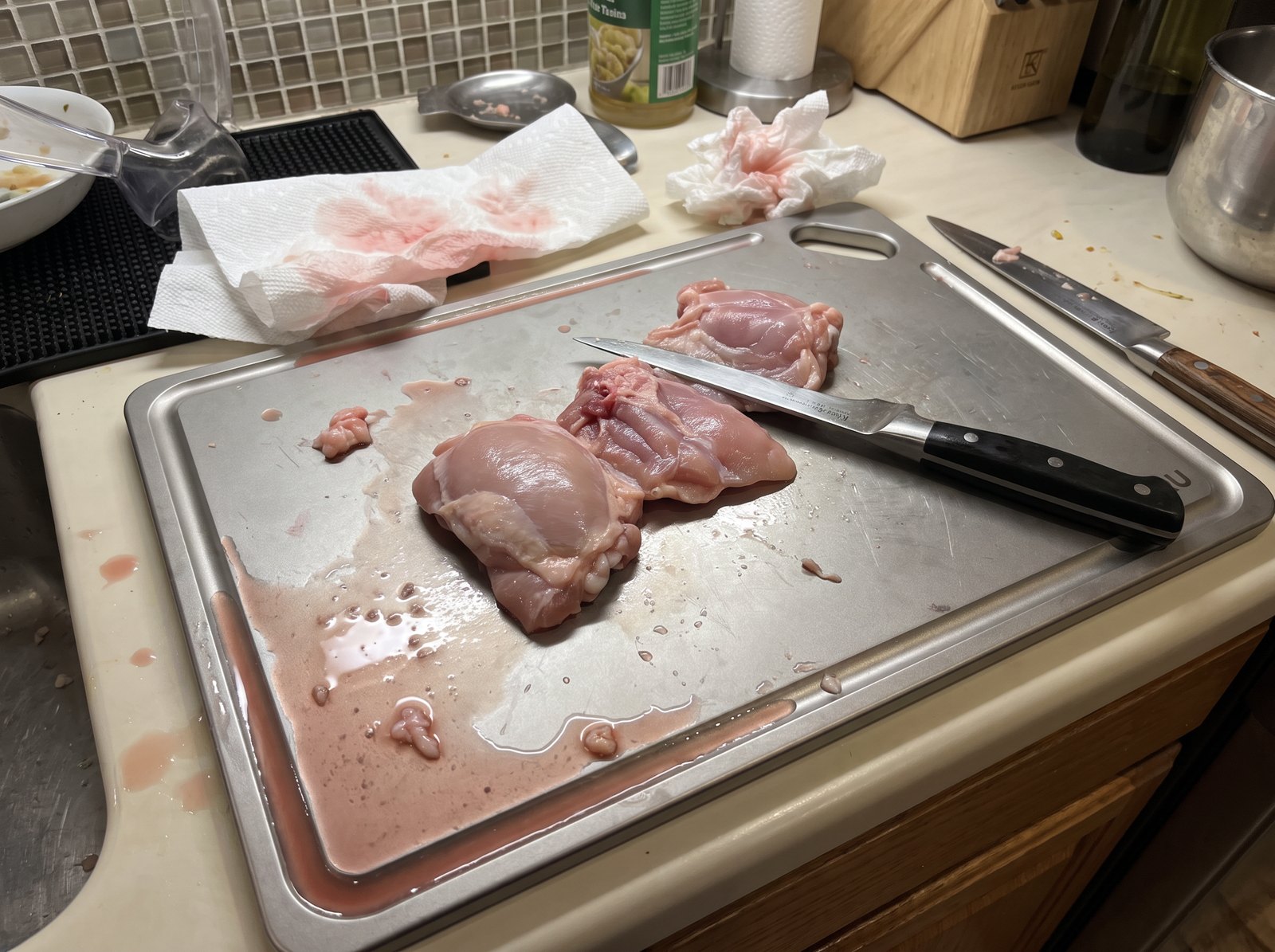 Raw chicken trimmed on the Kiru board with juice held in the groove