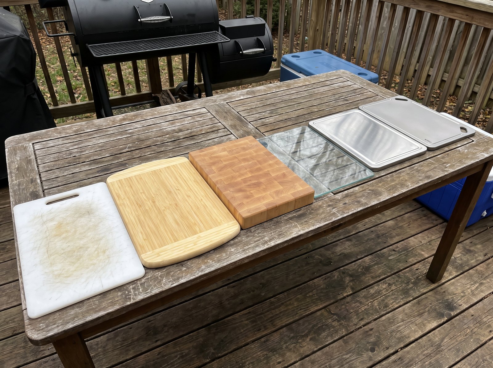 Six cutting boards lined up on a patio table